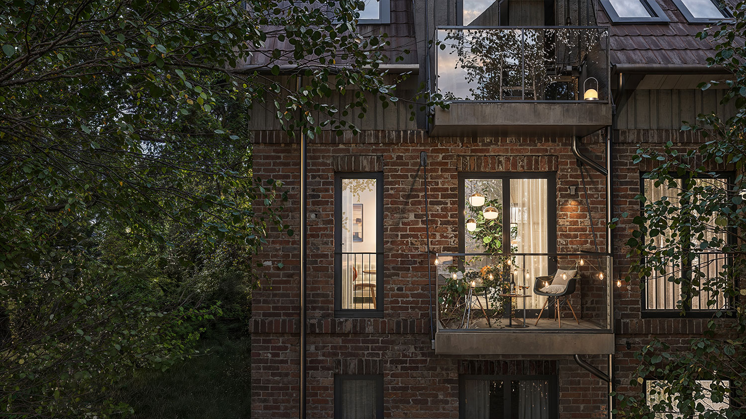 Exterior-Visualisierung in 3D von Strawberry Studio – Detailansicht einer beleuchteten Fassade mit Balkon in Nachtstimmung